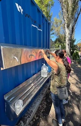 Мешканка набирає воду з водного модуля